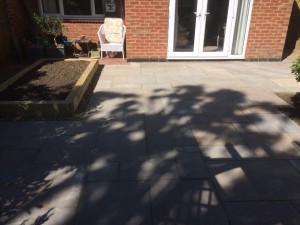 Sandstone paving with raised sleeper Vegetable bed.