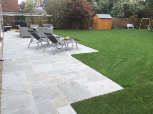 Grey Indian Sandstone paving, re turfed lawn, front block paved driveway with gravity set detail, planting scheme.